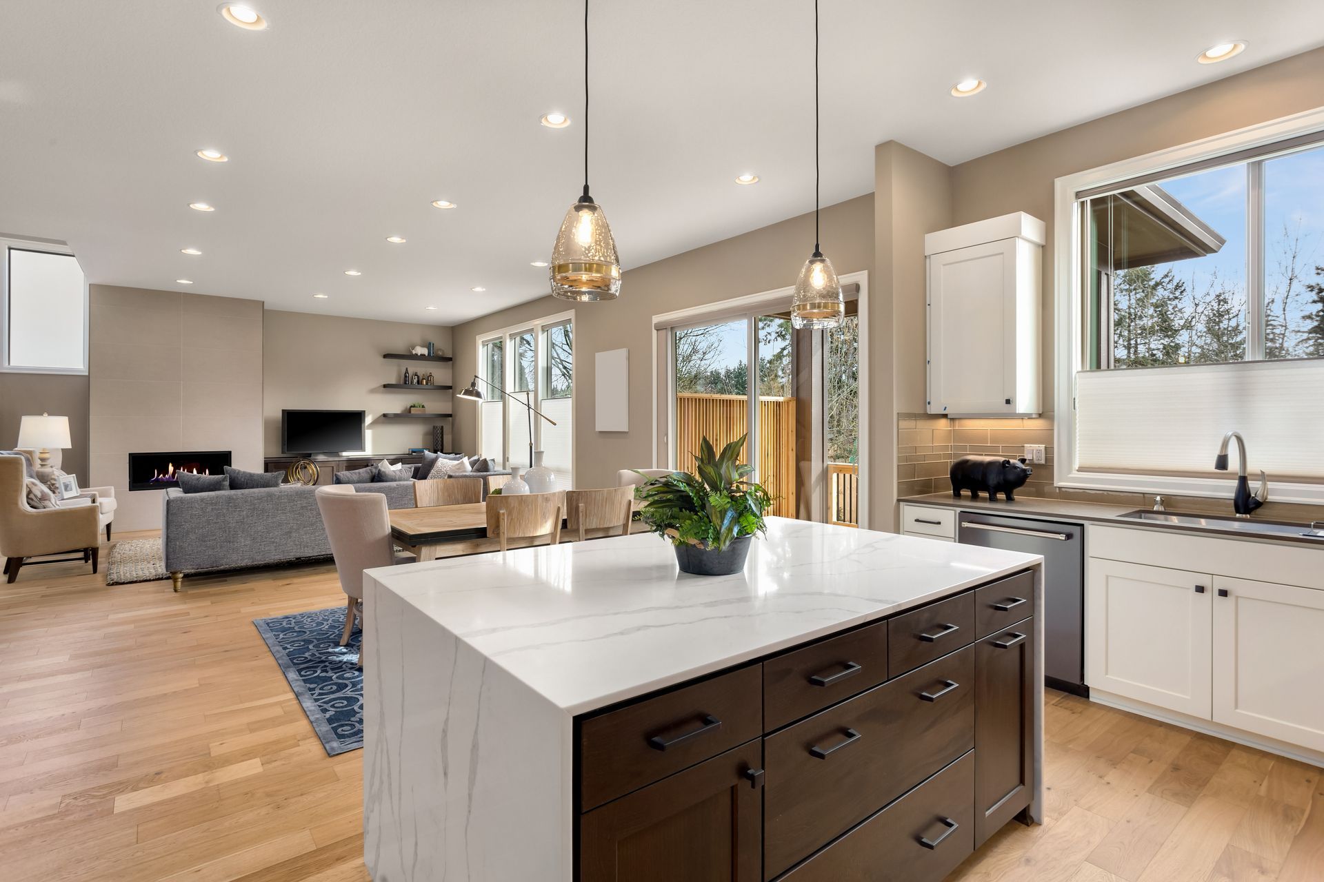 Bright New England home interior with wood floors, light cabinets, and neutral gray and beige furniture