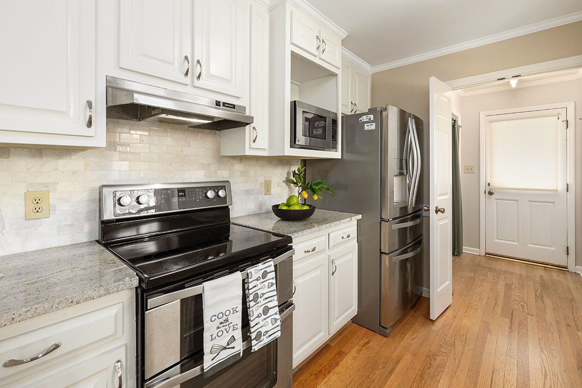 a kitchen with stainless steel appliances and white cabinets. Kitchen interior design project