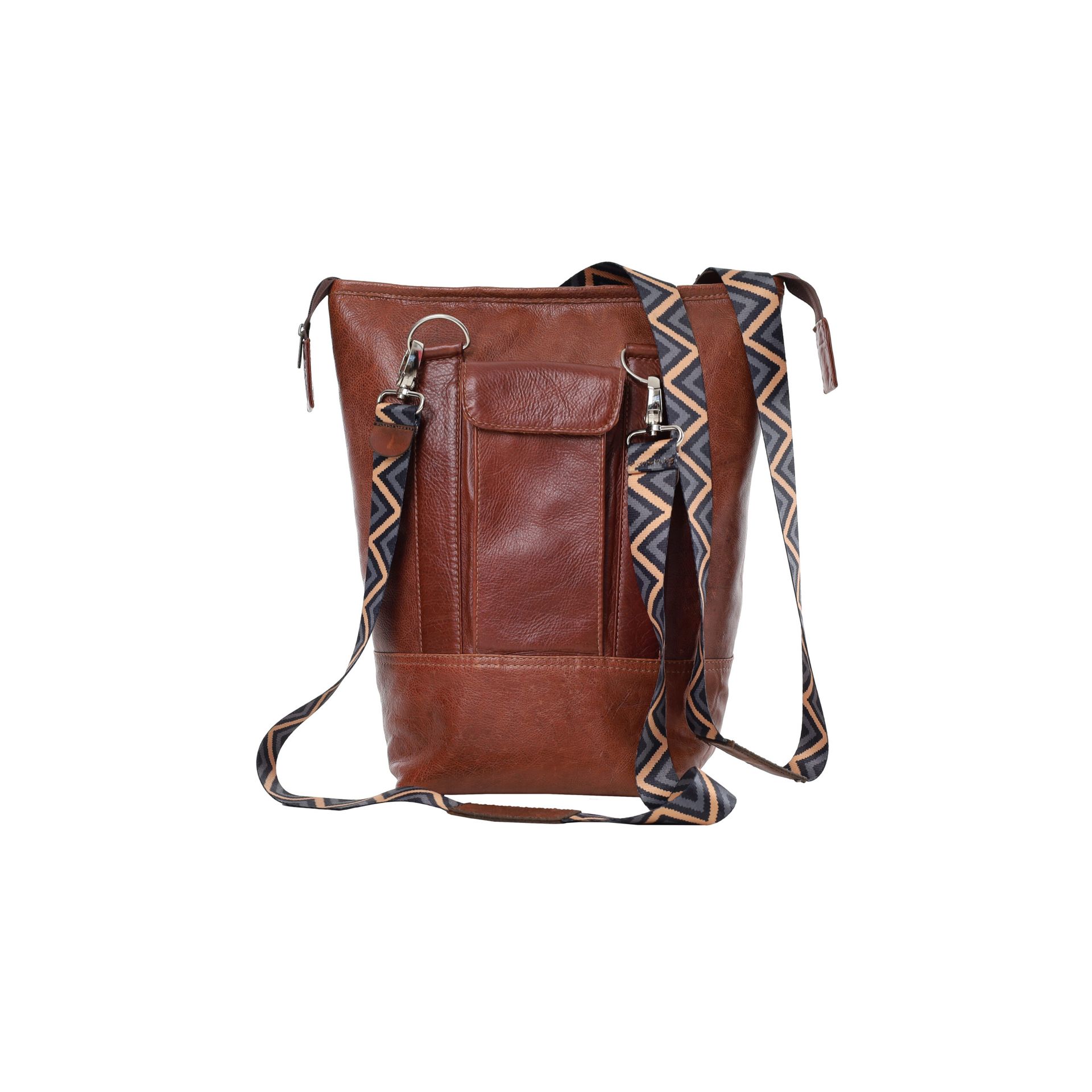Brown leather crossbody bag with patterned strap and front pocket, isolated on white background