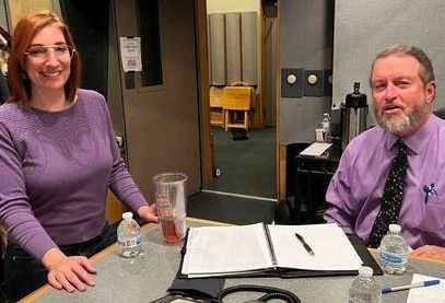 A man and a woman are sitting at a table with a stethoscope on it.