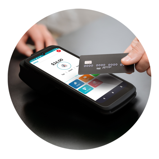 Contactless card being tapped on a smartphone payment terminal on a dark table