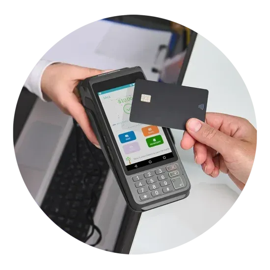 Hand holding a card to a payment terminal with a touchscreen and keypad