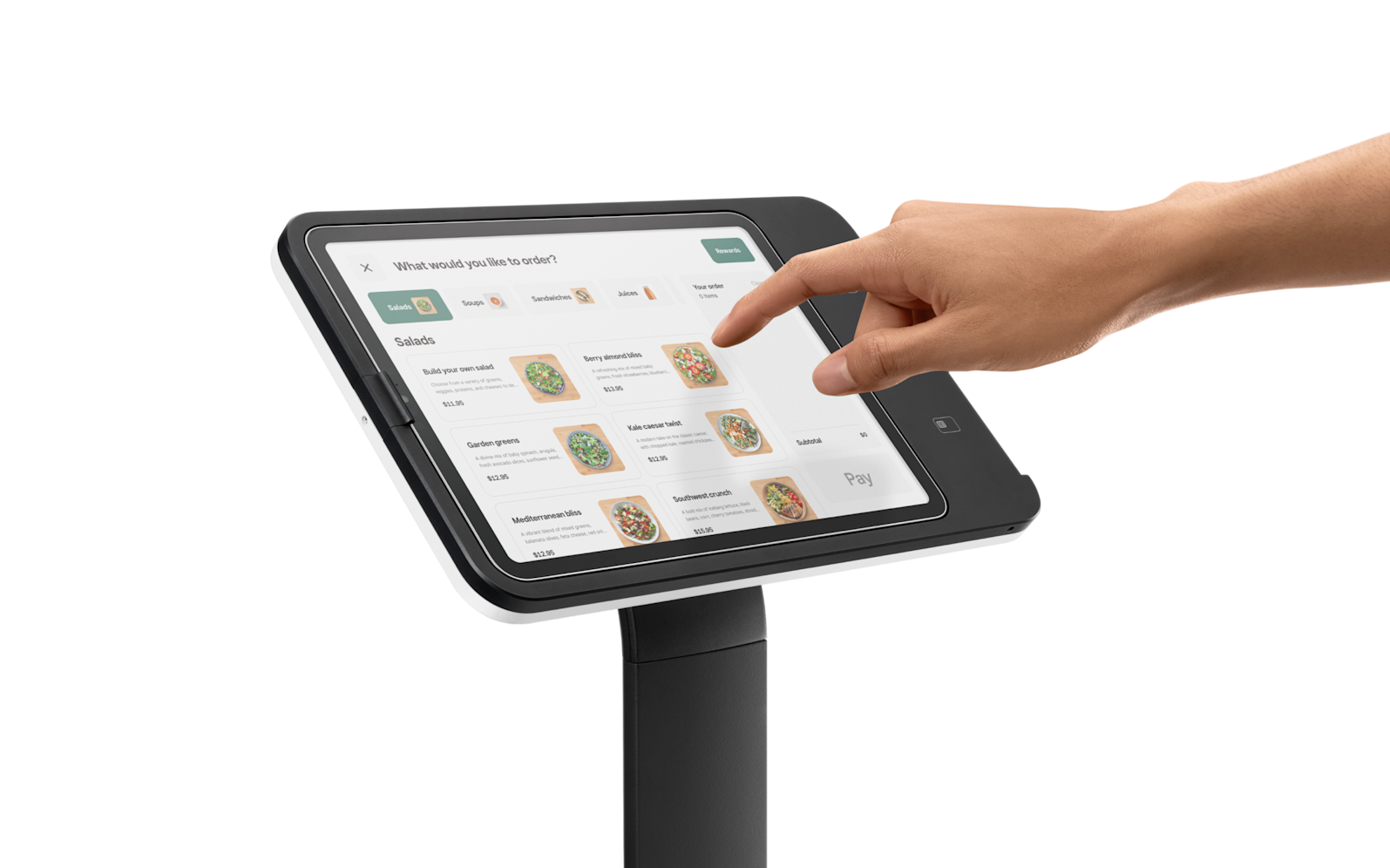 Hand tapping a tablet mounted on a stand, showing a grid of app icons.