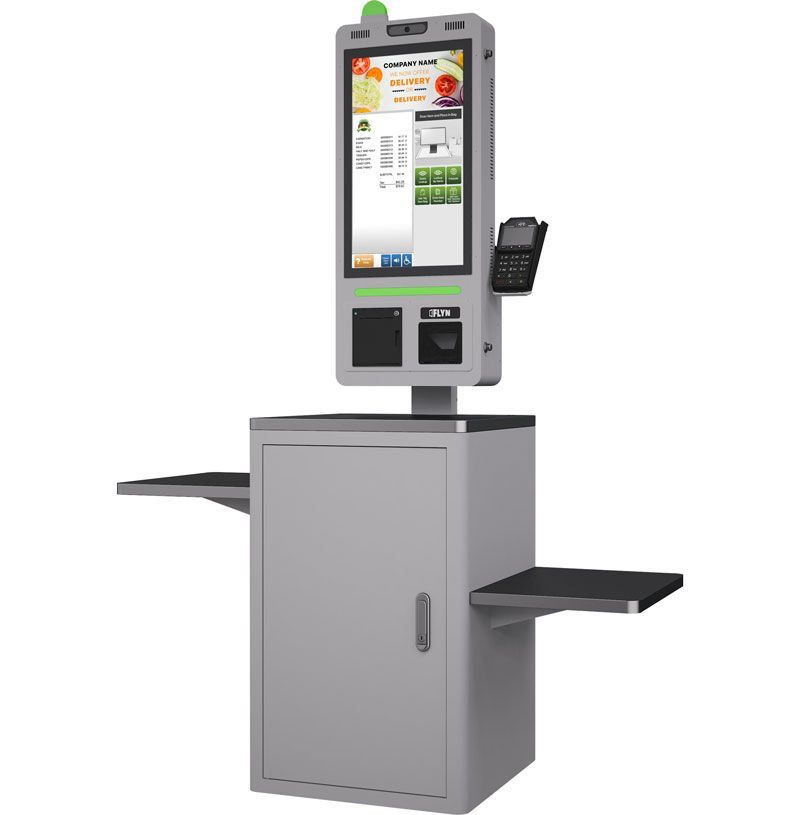 Gray self-service kiosk with touchscreen, card reader, and side shelves on a cabinet base
