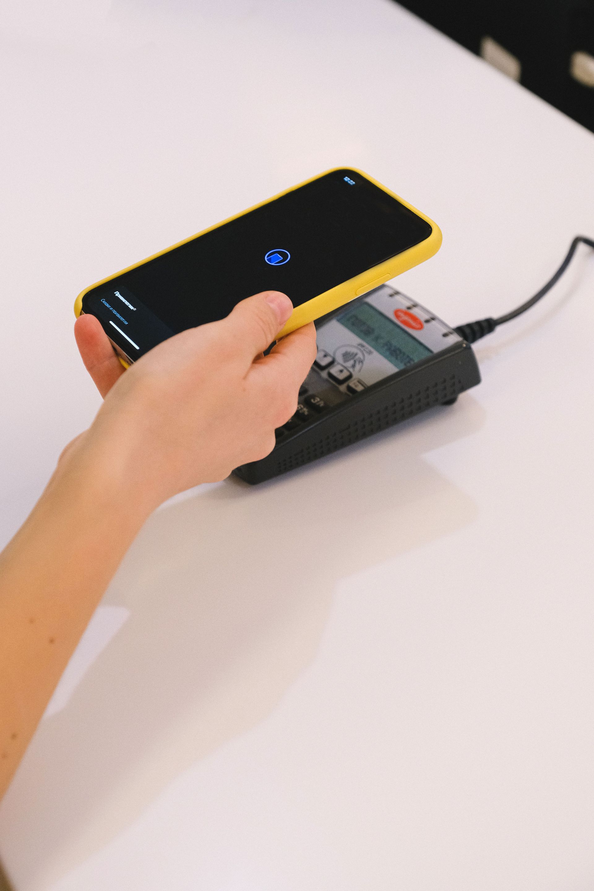Hand using a card payment terminal during a merchant transaction