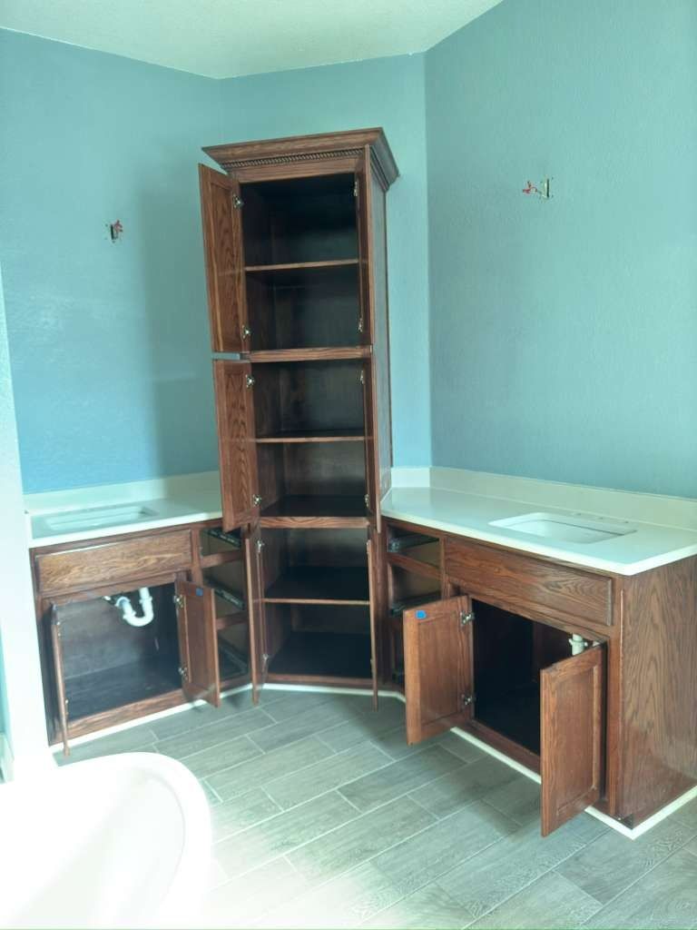 Empty kitchen with teal walls and dark wood cabinets under installation.