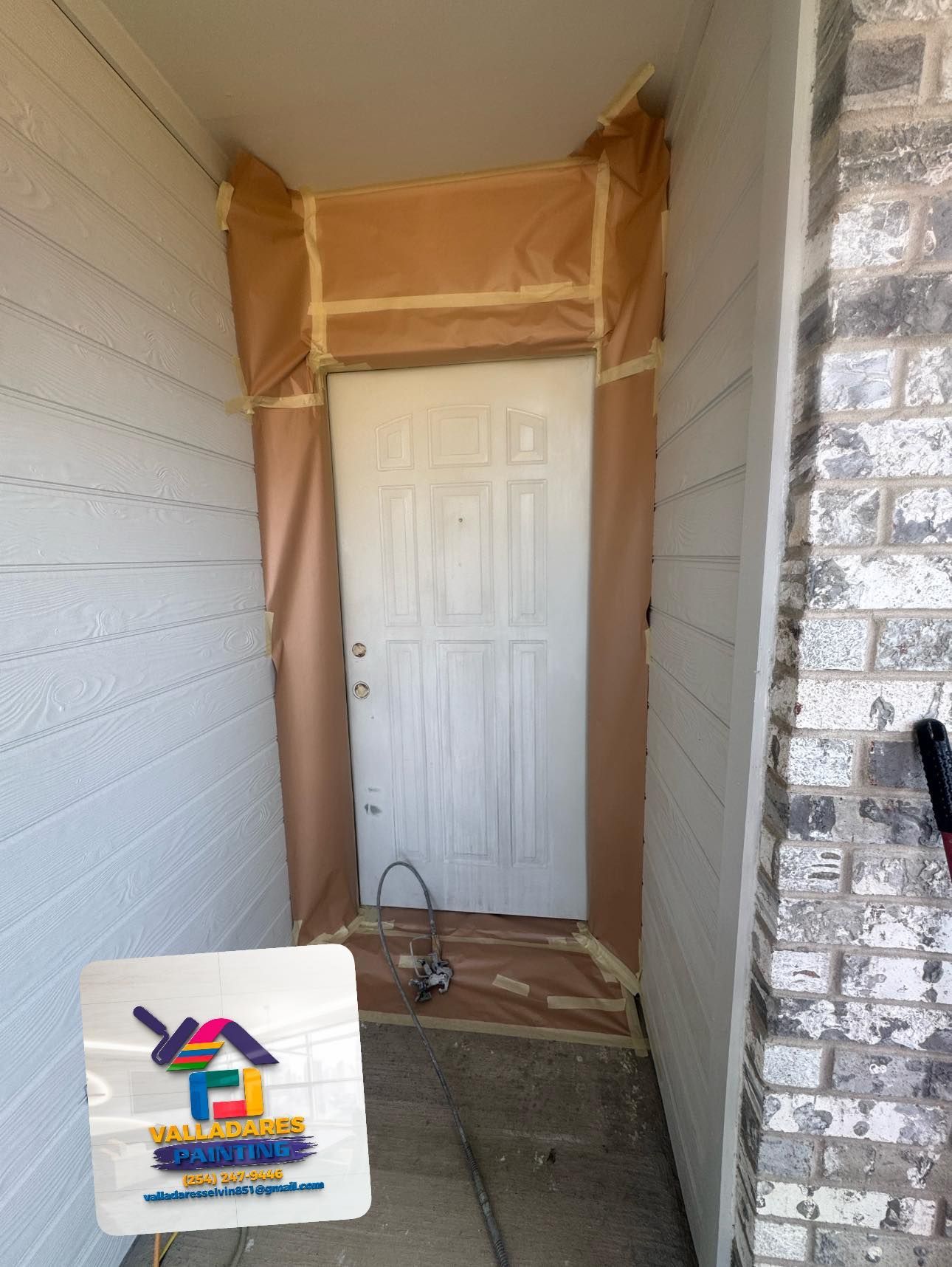 Front porch entryway with a white door, beige walls, and protective plastic sheeting overhead.