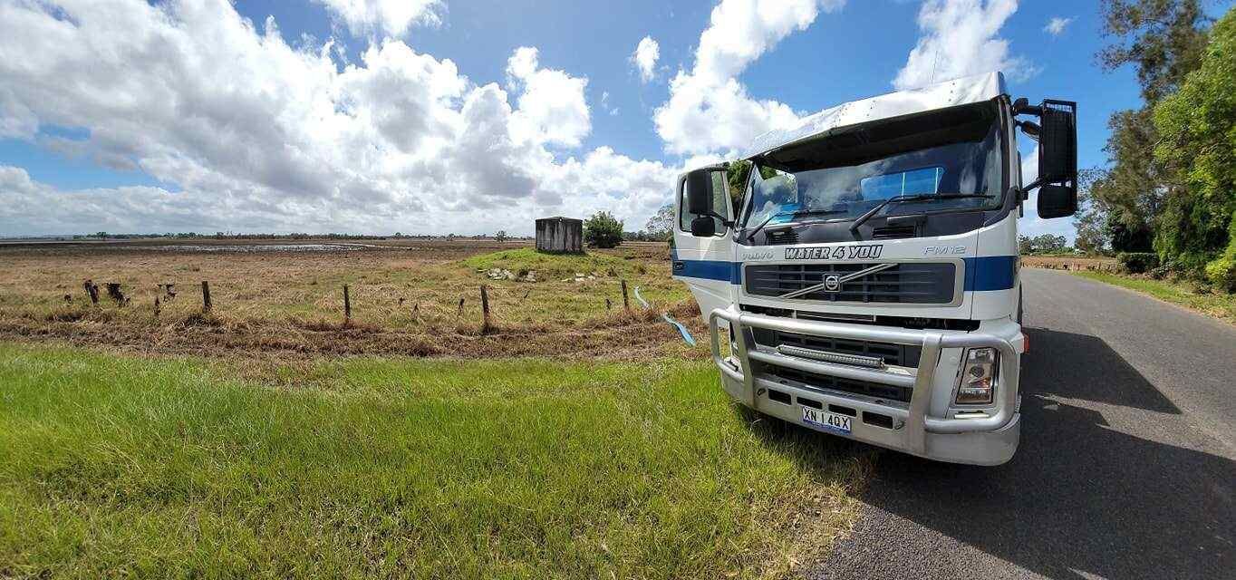 A White Truck is Parked on the Side of a Road Next to a Field — Water 4 You In Clovass, NSW