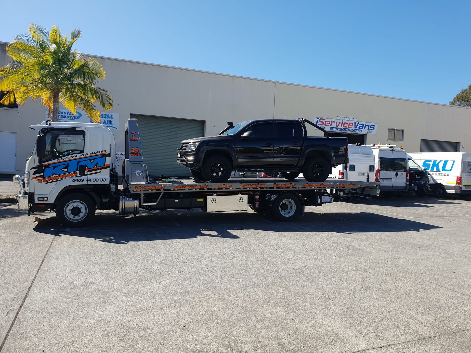 A Black Truck Is Sitting On Top Of A Flatbed Tow Truck — KTM Towing In Kempsey, NSW
