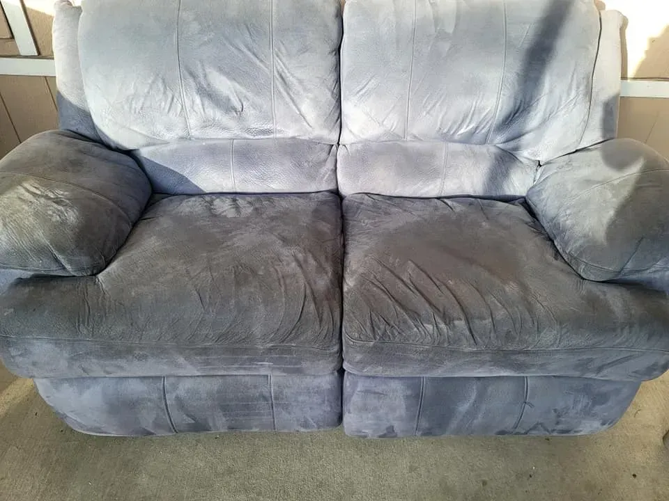 Light blue plush two-seat sofa with dark gray armrests and cushions