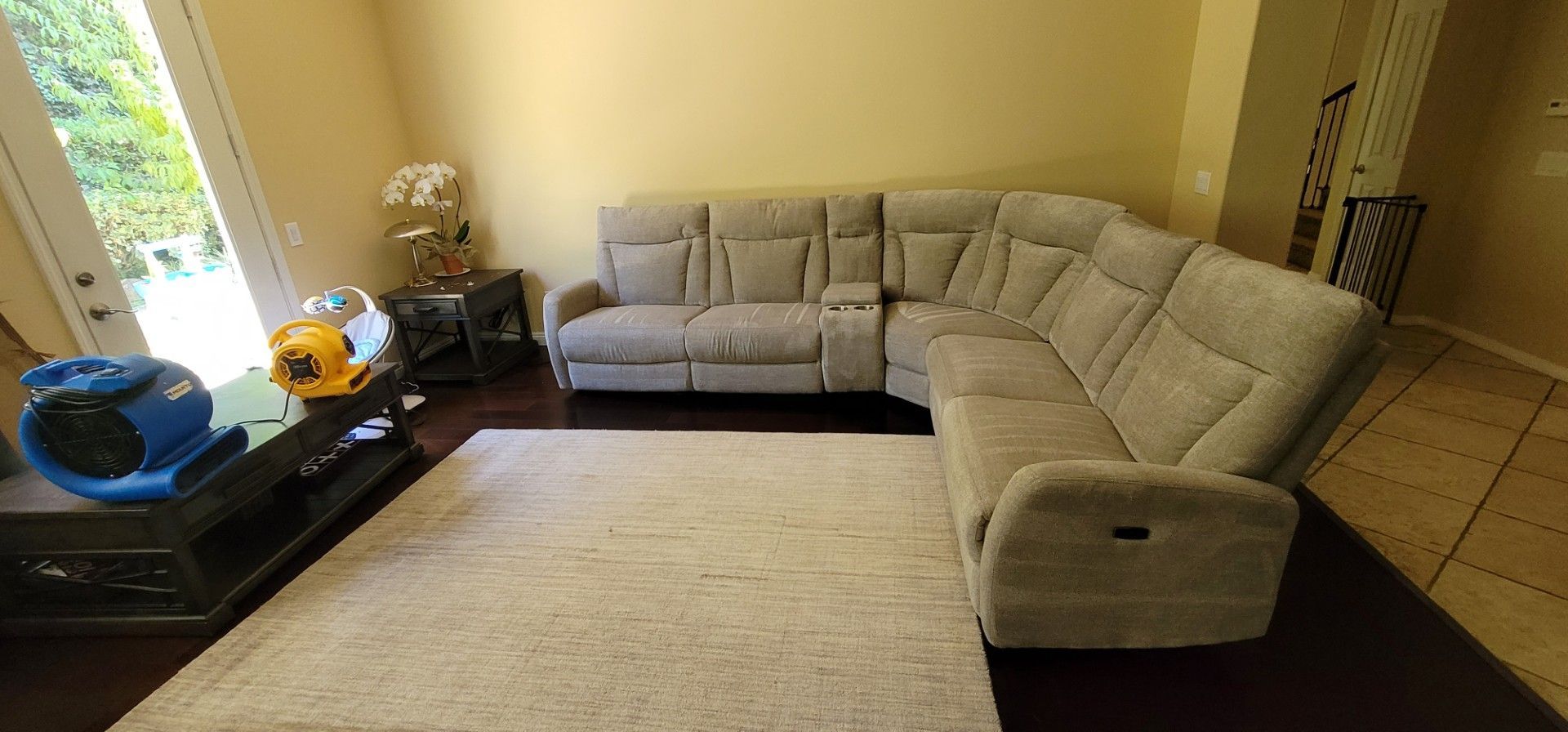 Bright living room with beige sectional sofa, large rug, and window-side side table