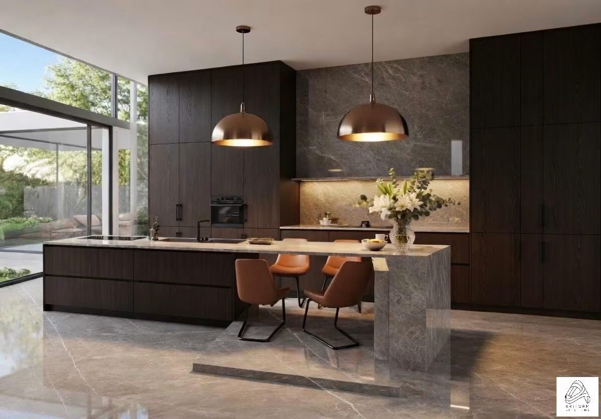 Modern kitchen with dark cabinetry, stone island, copper pendant lights, and two stools by a large window.