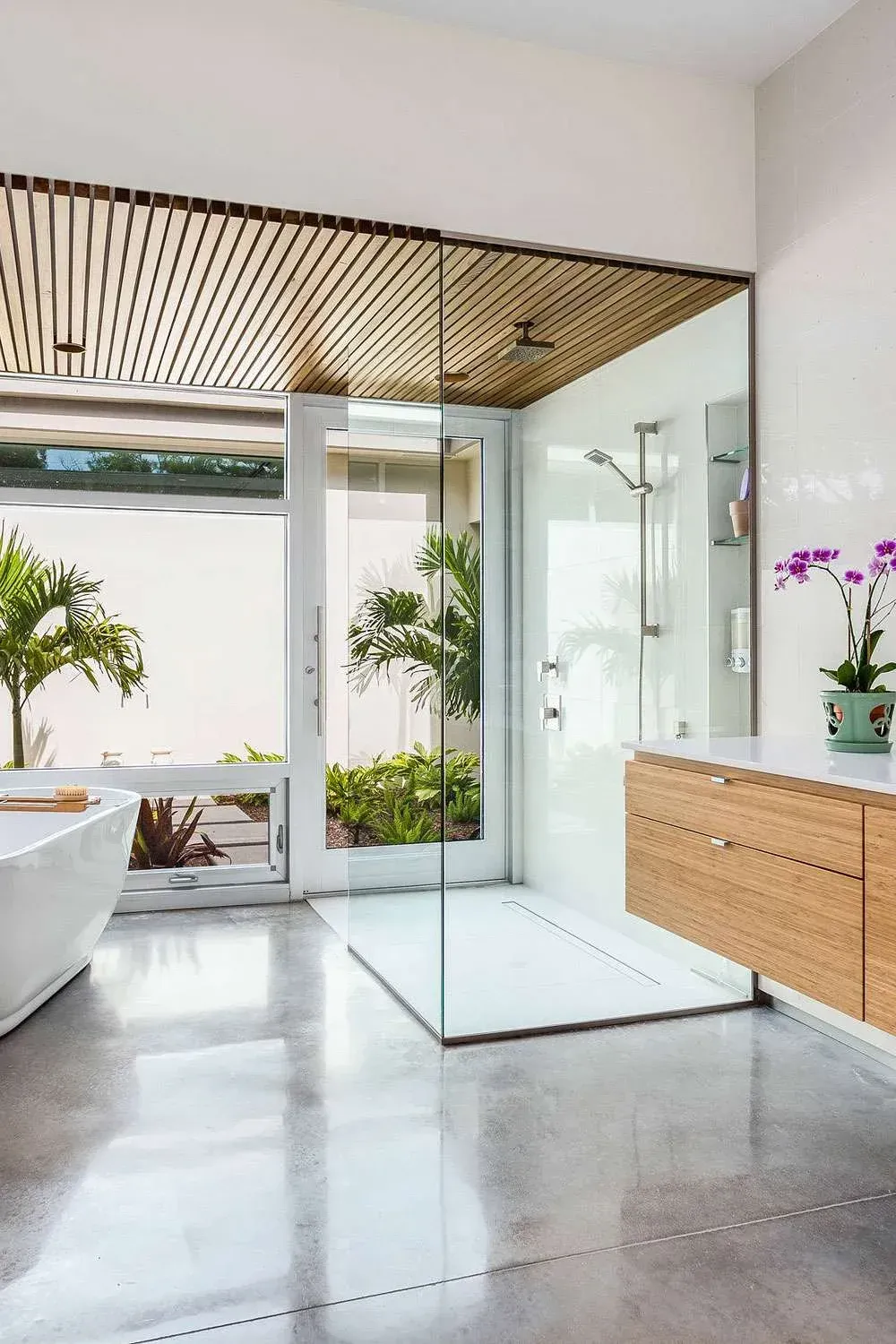 Open shower and timber cabinetry renovation with orchids and greenery in Neutral Bay”