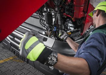 a man is working on the engine of a truck .