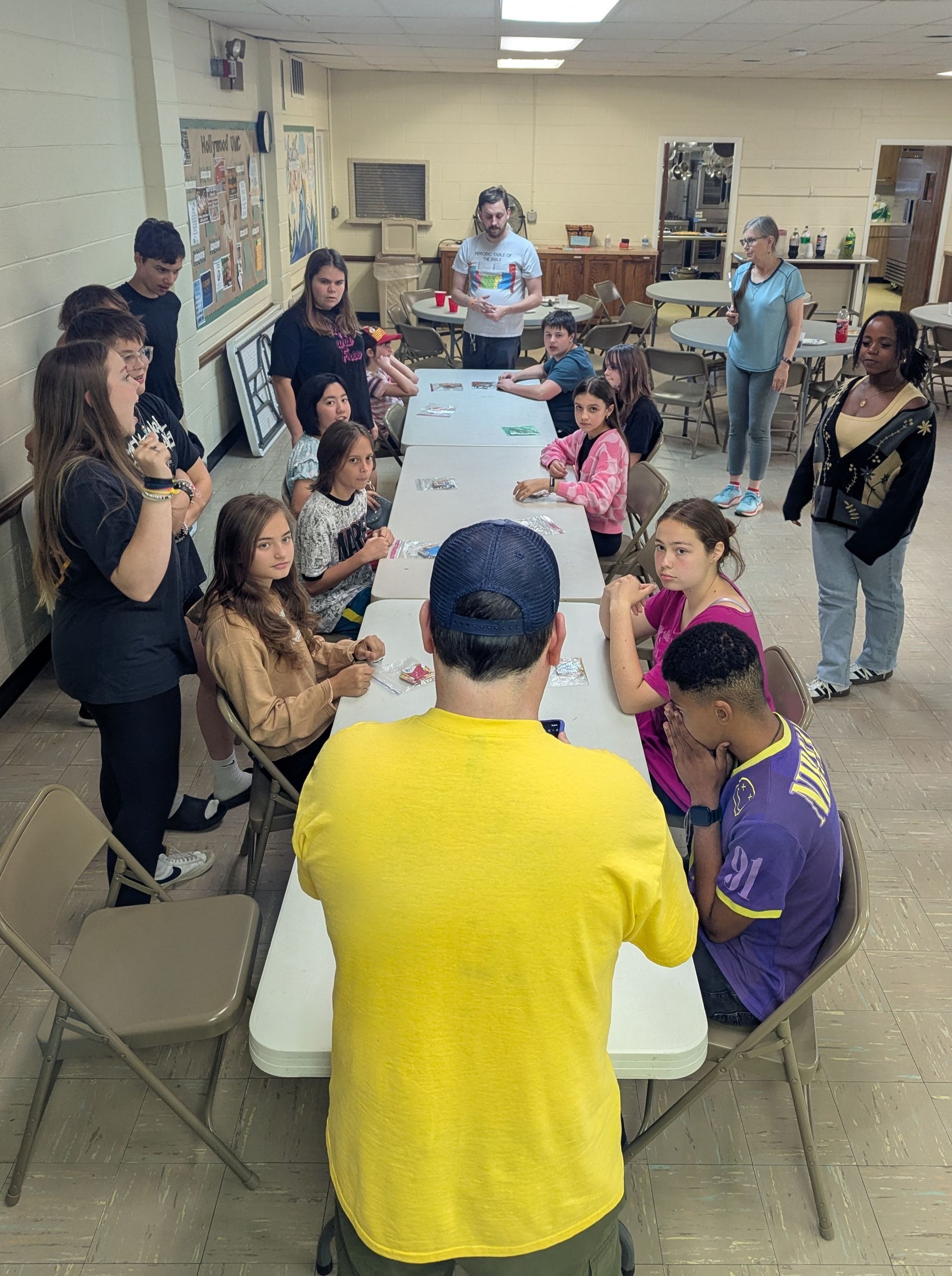 Youth at a table, arranging puzzle pieces. Indoors, casual setting.