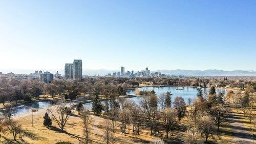 An aerial view of a park with a city skyline in the background.