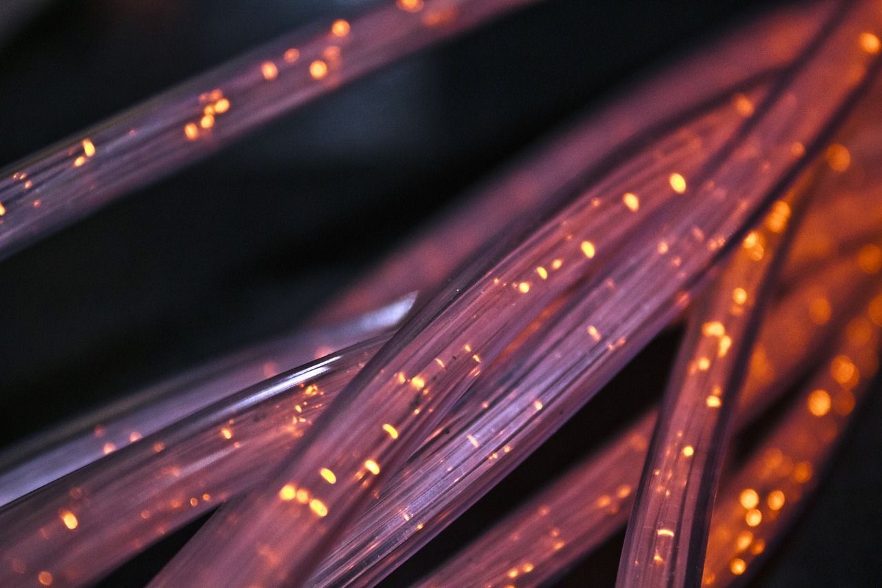 A close up of a bunch of purple and orange fiber optic cables.