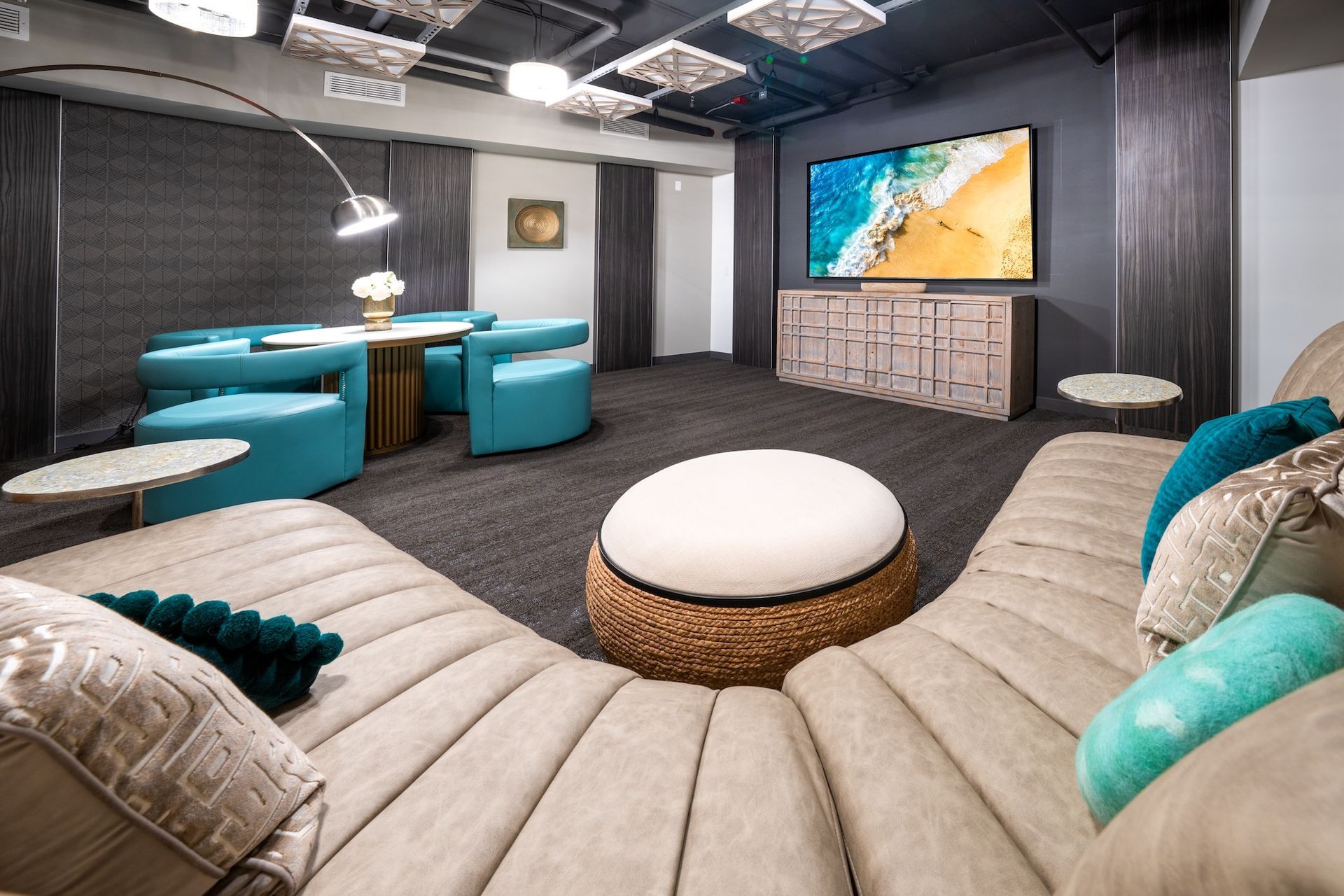 A living room with a couch , ottoman , chairs and a television.