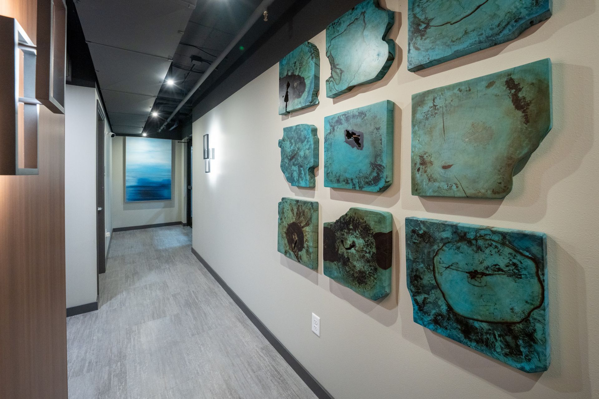 A hallway with a lot of paintings on the wall.