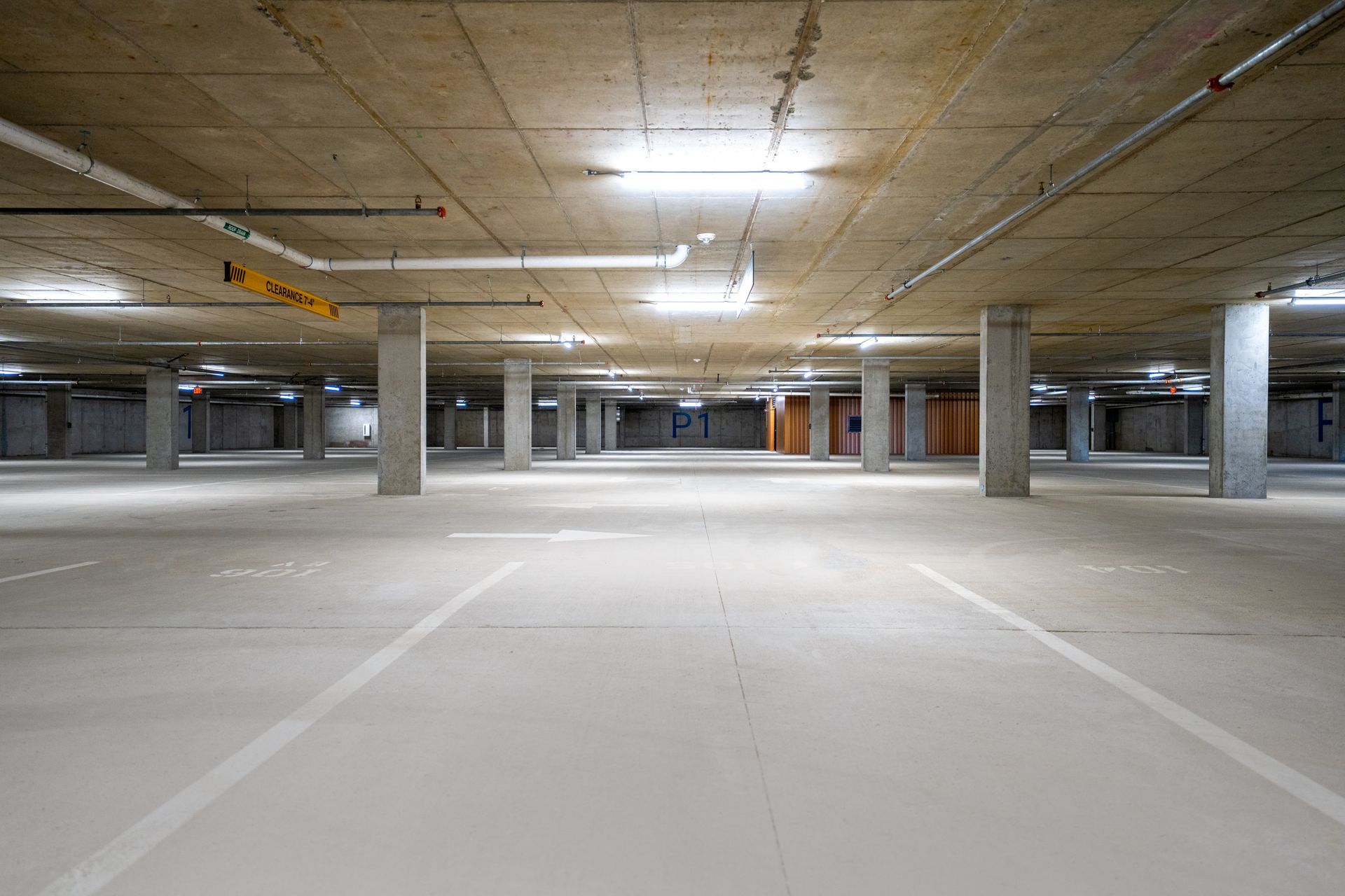 An empty underground parking garage with a lot of parking spaces.