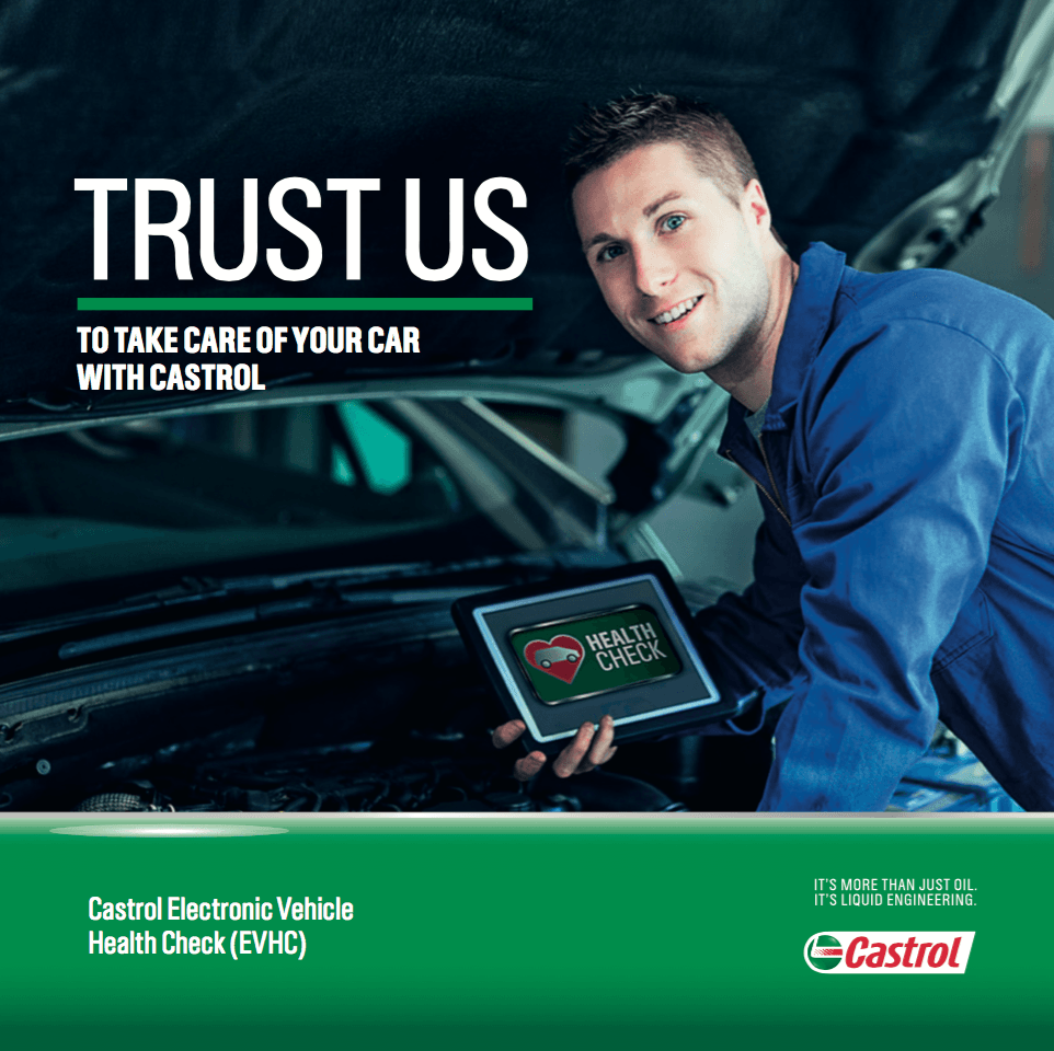 A man is holding a tablet in front of a car.