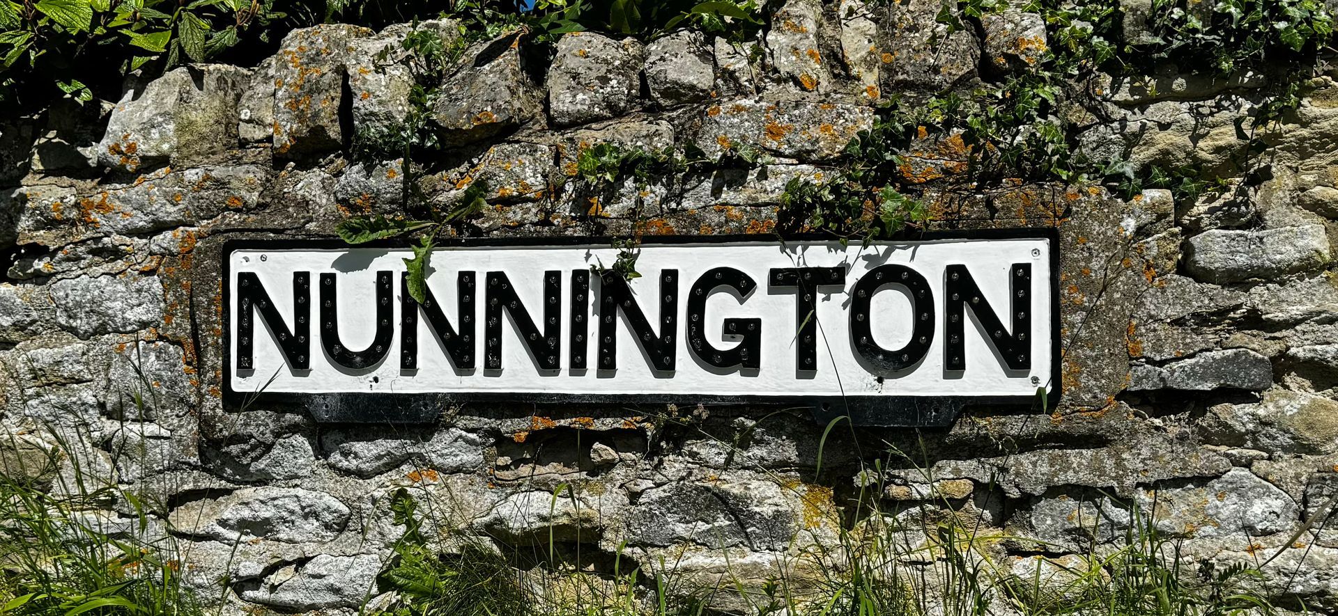 A sign on a stone wall that says nunnington