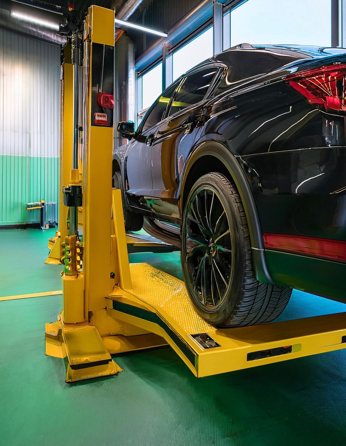 The image shows an Audi like vehicle racked on a hoist to be serviced by one of our expert Audi repair mechanics in Redwood City, CA.