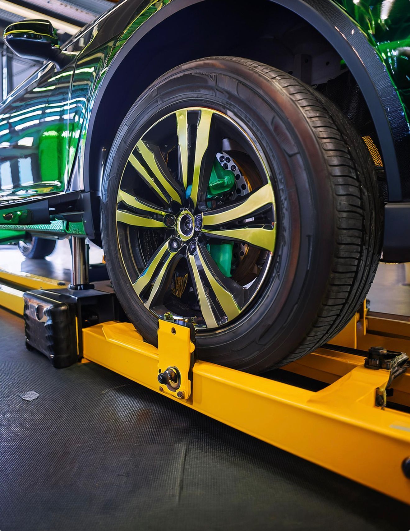the image shows a vehicle racked on an automotive tire alignment rack to address uneven tire wear in Redwood City, CA