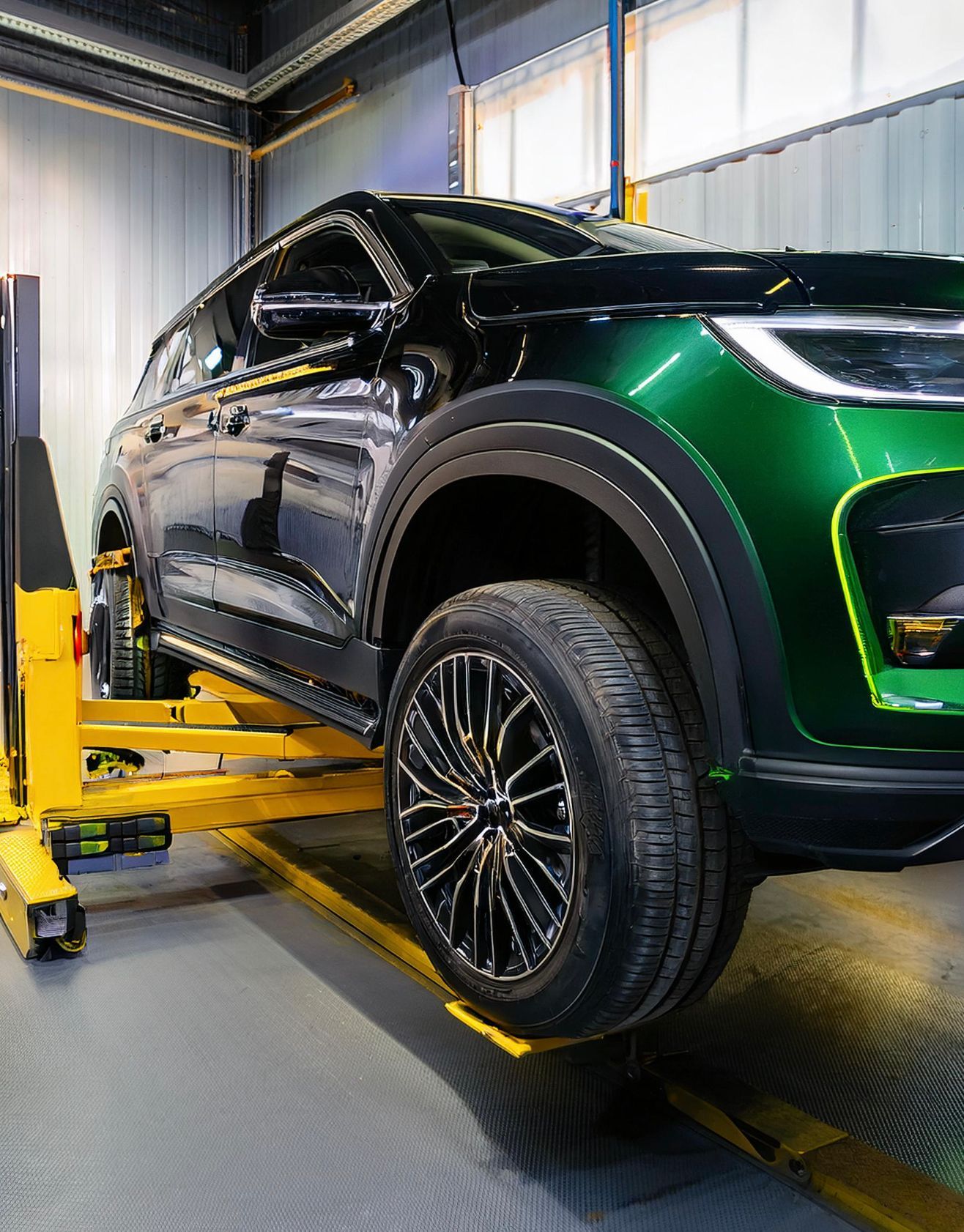 The image shows a Chrysler-like vehicle racked on our mechanics auto repair and service hoist in Redwood City, CA.
