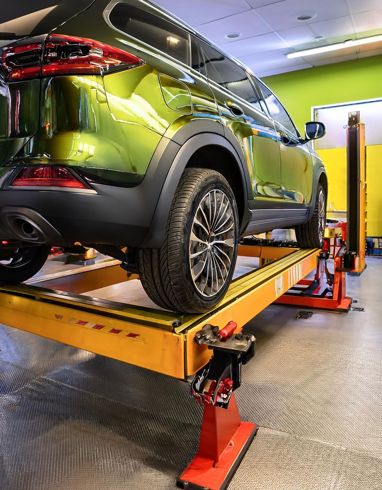 The image shows a Dodge like vehicle racked on our mechanics lift hoist in preparation for auto repair & service in Redwood City, CA