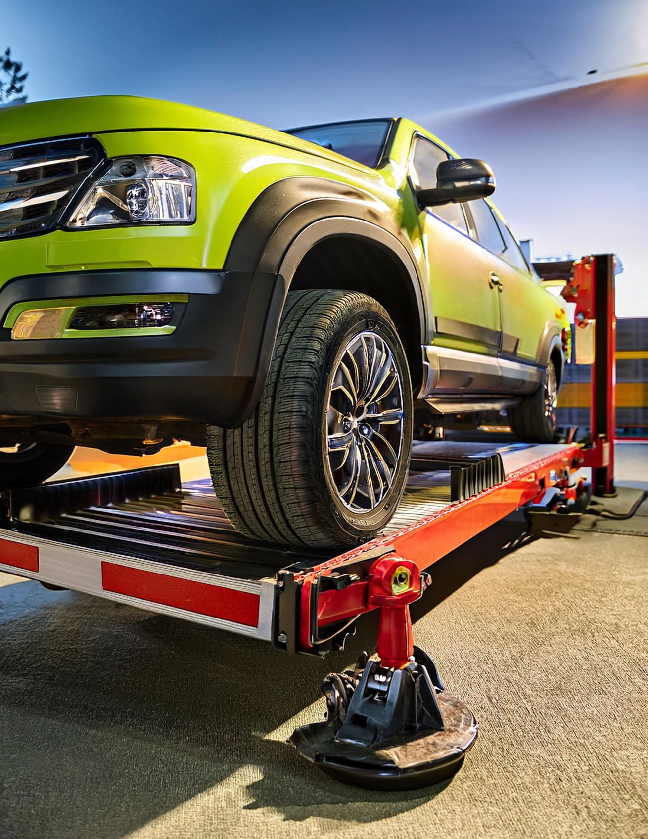 The image shows a GMC vehicle racked on our mechanics' auto repair hoist in preparation for auto repair and service in Redwood City, CA.