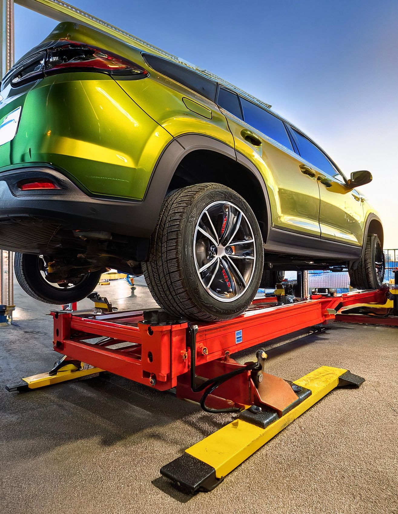 The image shows a Hyundai-like vehicle racked on our mechanics rack in preparation for auto repair and maintenance work at our auto repair facility in Redwood City, CA.