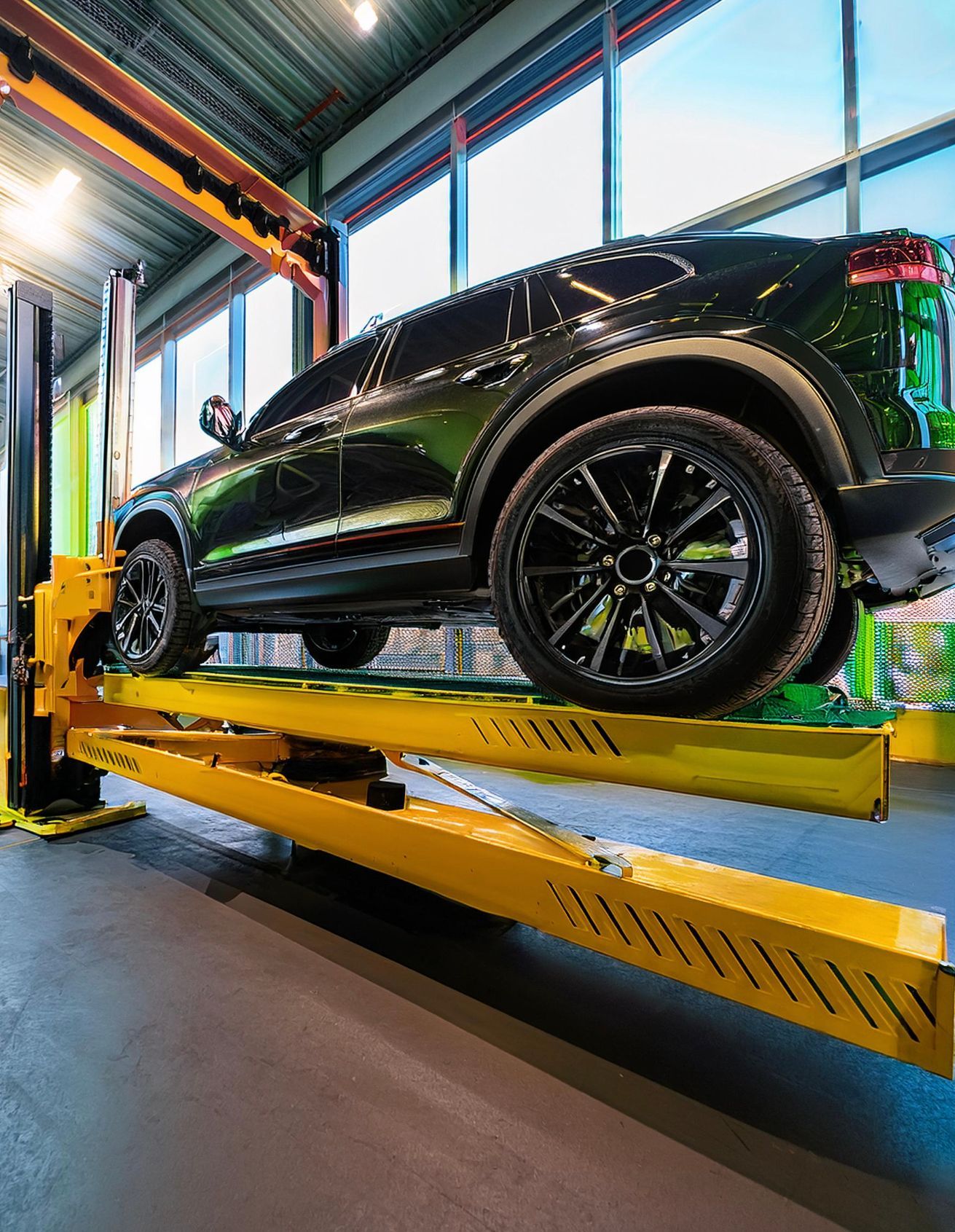 The image shows an Infiniti-like vehicle racked on our mechanics' auto repair rack in preparation for auto repair and maintenance services at our auto repair facility in Redwood City, CA