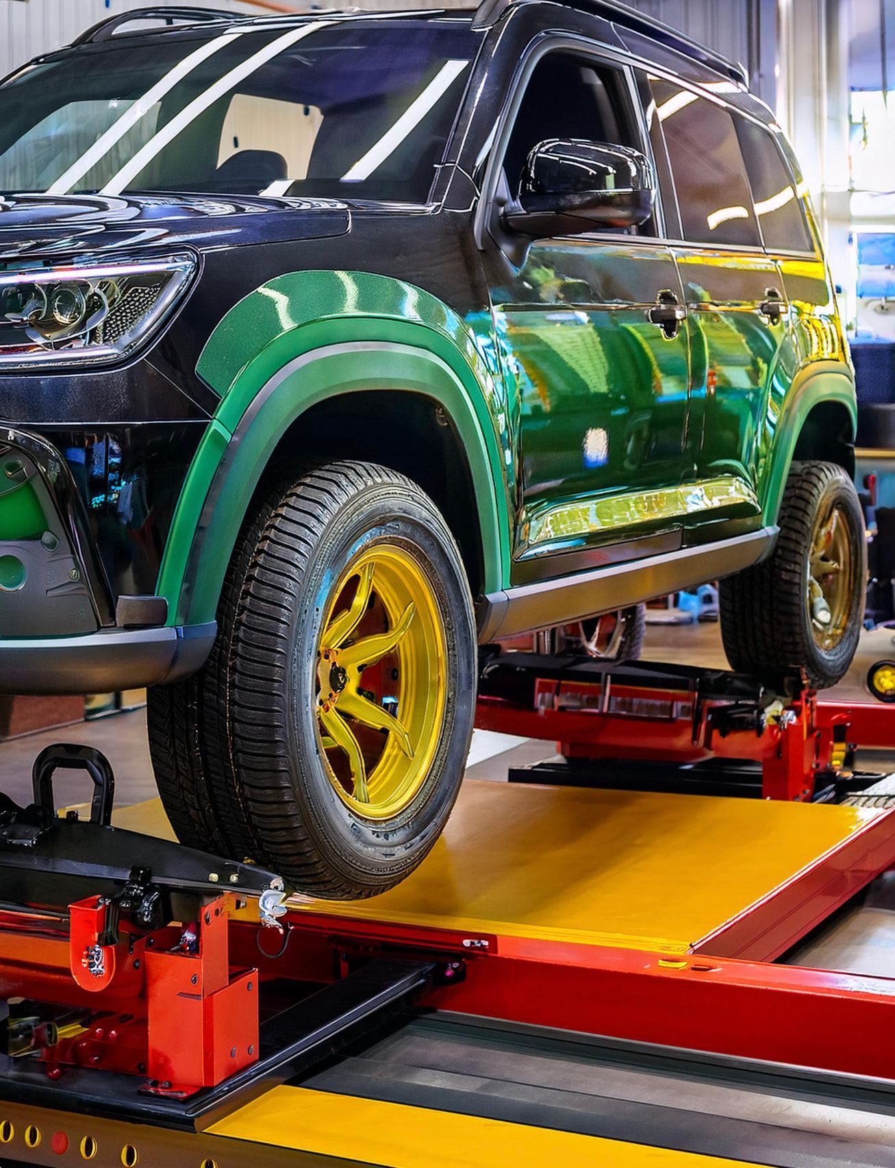 The image shows a Kia like vehicle racked on our auto repair hoist in preparation for auto repair and maintenance services at our auto repair facility in Redwood City, CA.