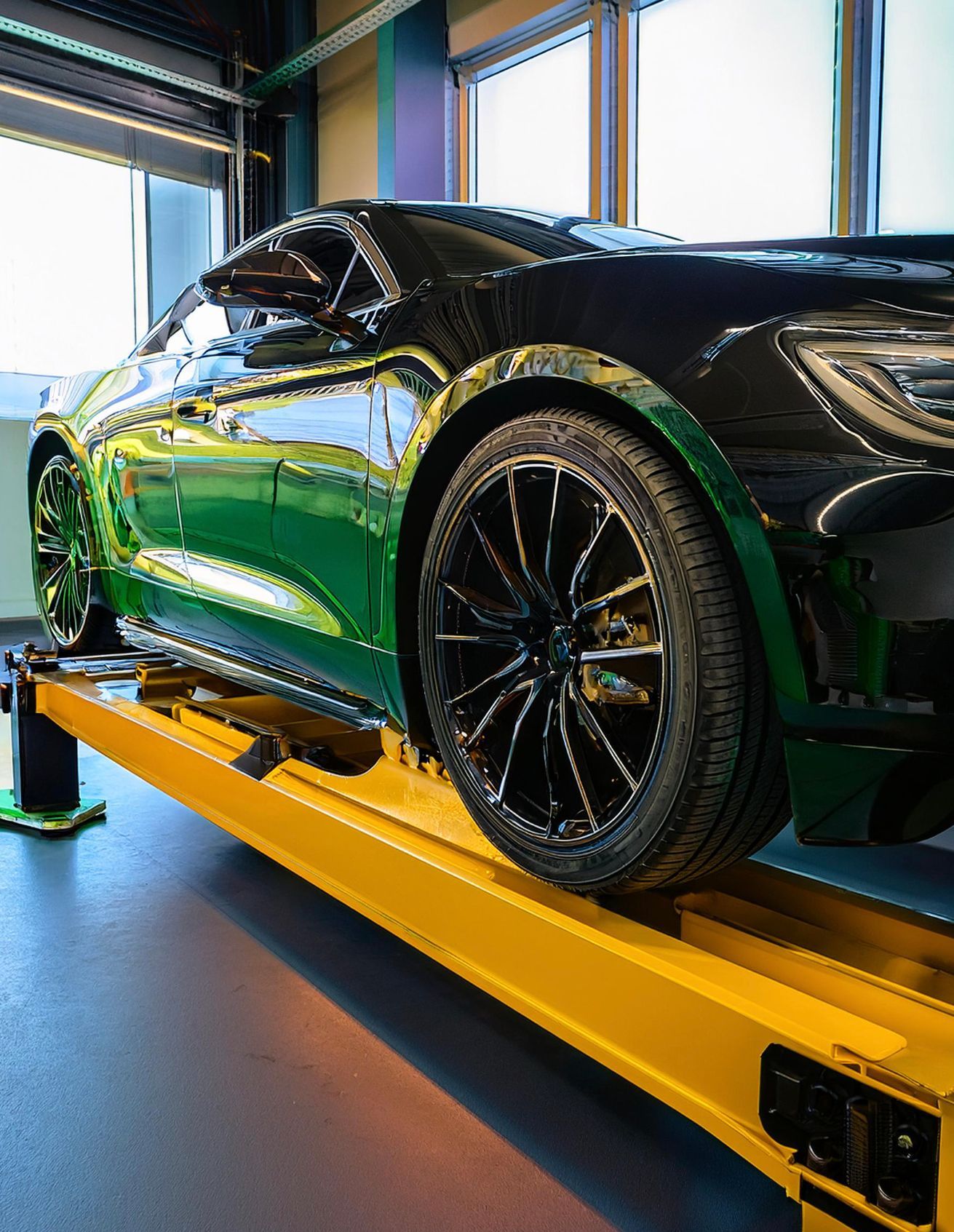The image shows a Lincoln-like vehicle racked on our mechanics' rack in preparation for auto repair and maintenance services at our facility in Redwood City, CA