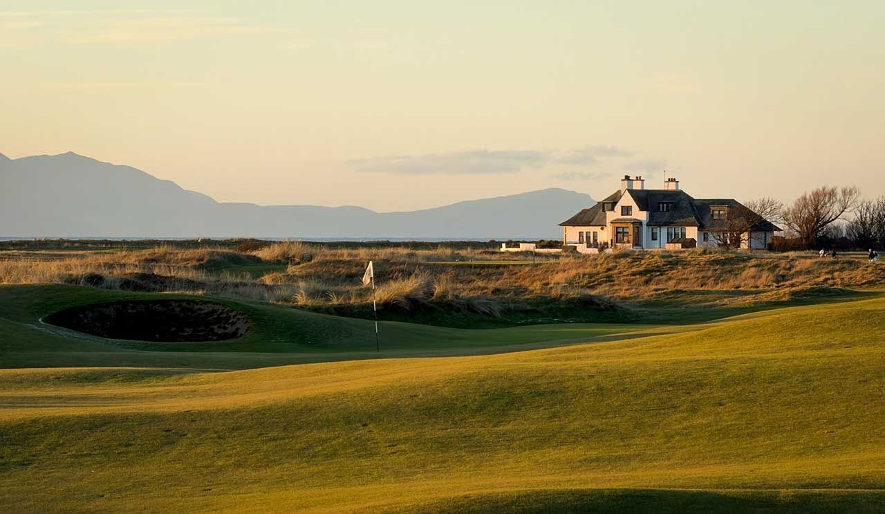 Rolling green golf course with blackrock house at sunset and Arran in the distance