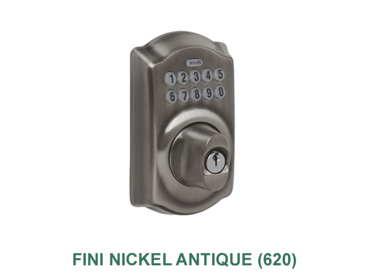 Une serrure de porte antique en nickel avec une clé dessus