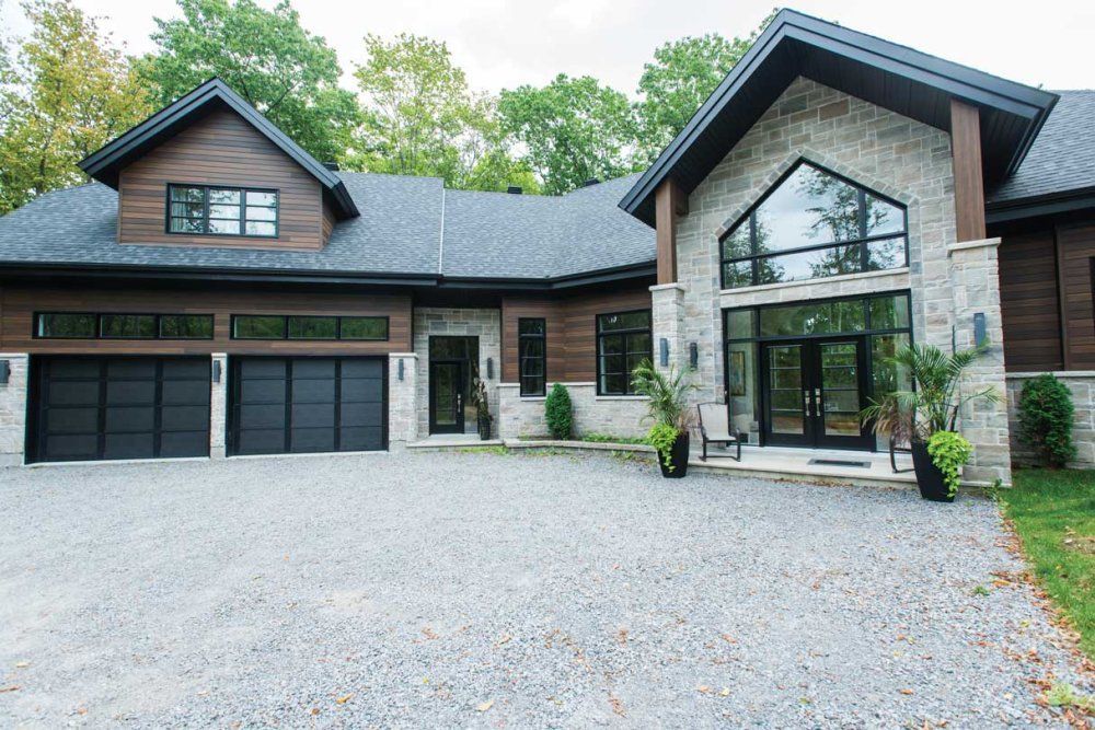 une grande maison avec beaucoup de fenêtres et une allée devant.