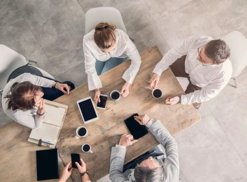 Four People in Business Attire at a Wooden Table — SSP Insurance In Rockhampton City, QLD