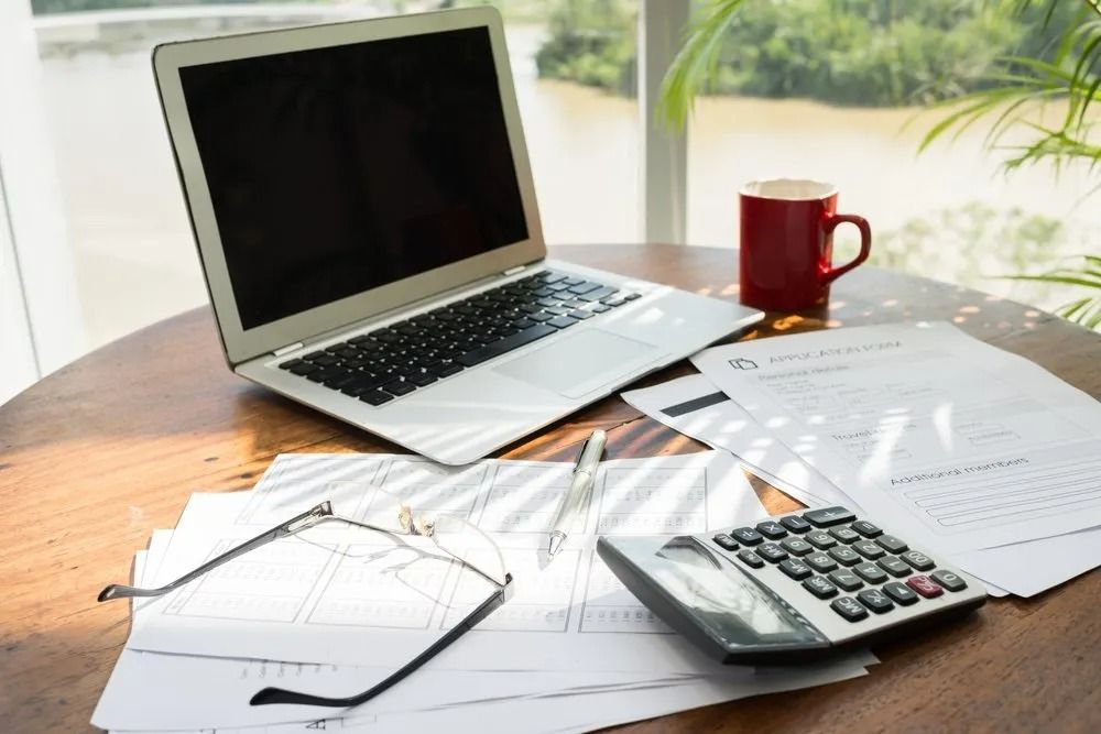 Laptop, Papers, Calculator, Eyeglasses, and Coffee Cup — SSP Insurance In Rockhampton City, QLD