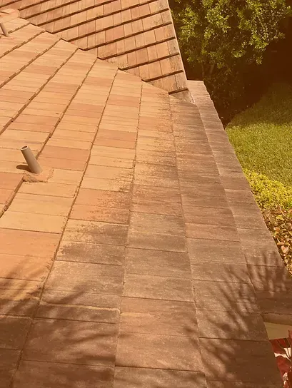 A close up of a tiled roof with a drain on the side of it.