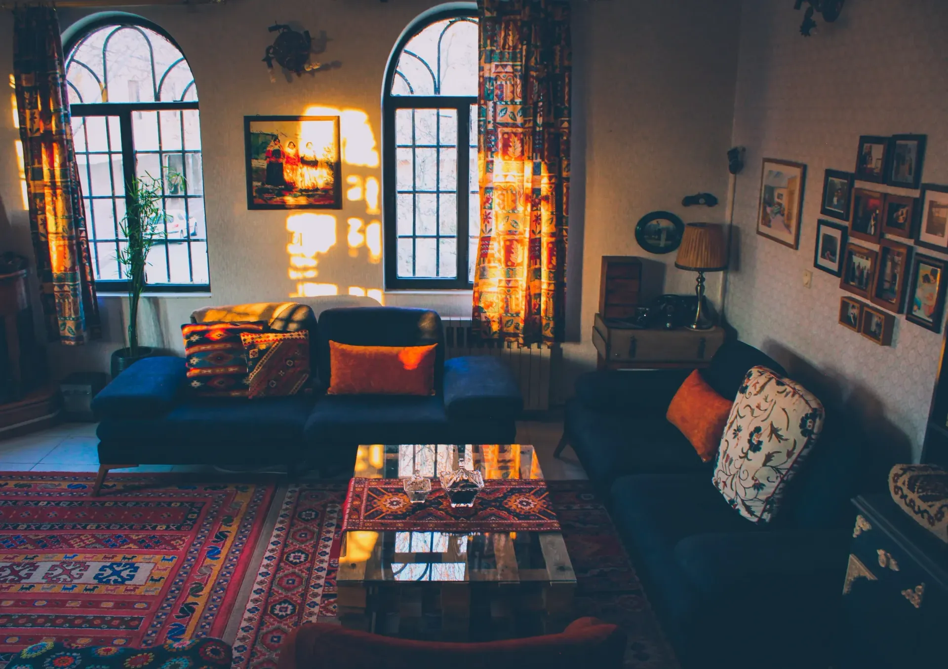 A living room with a couch , rug , coffee table and windows.