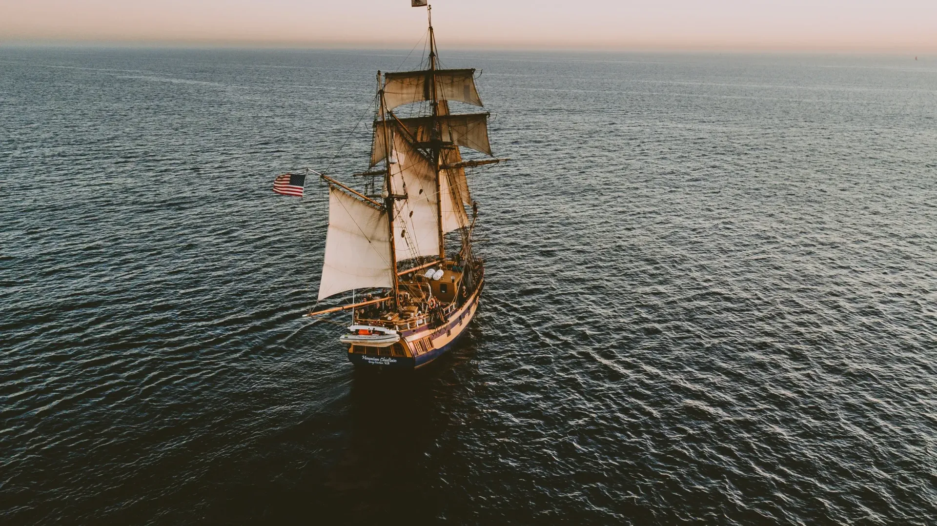 A sailboat is floating on top of a large body of water.