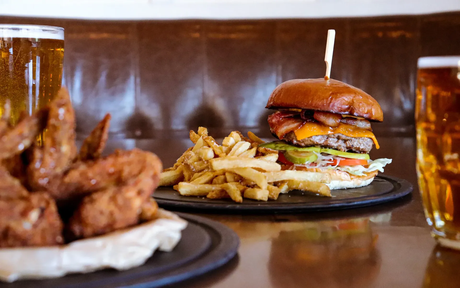 A table topped with plates of food and a glass of beer.