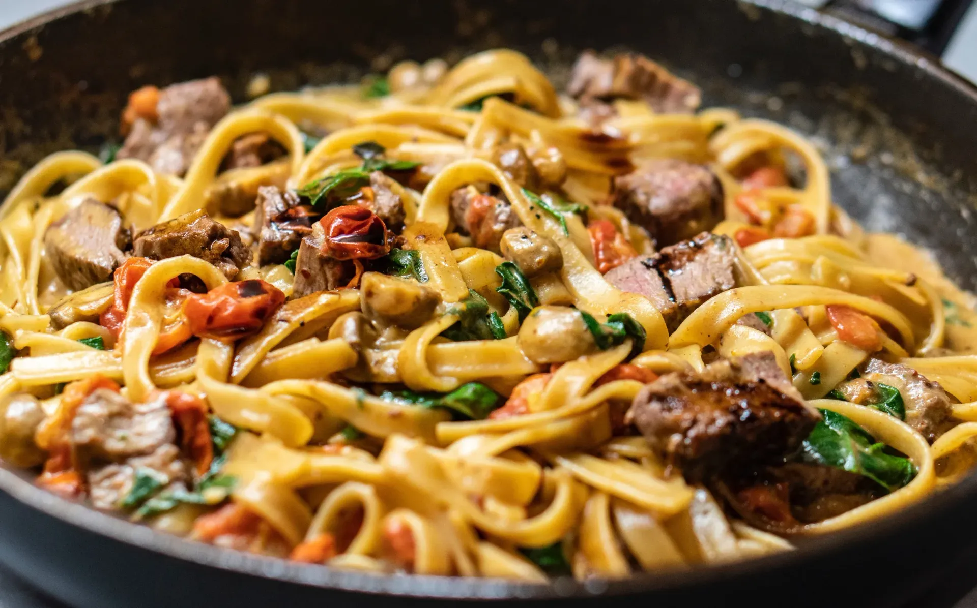 A close up of a pan of pasta with meat and vegetables.
