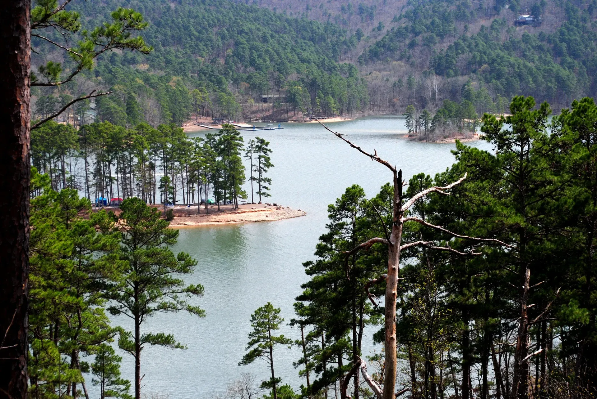 A large body of water surrounded by trees and mountains.