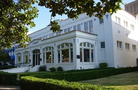 A large white building with lots of windows and a porch
