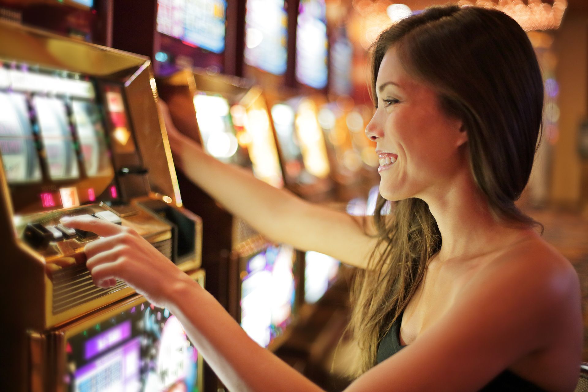 A woman is playing a slot machine in a casino.