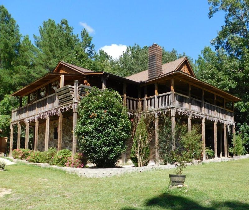 A church with a wooden roof and a wooden door in the middle of a forest.