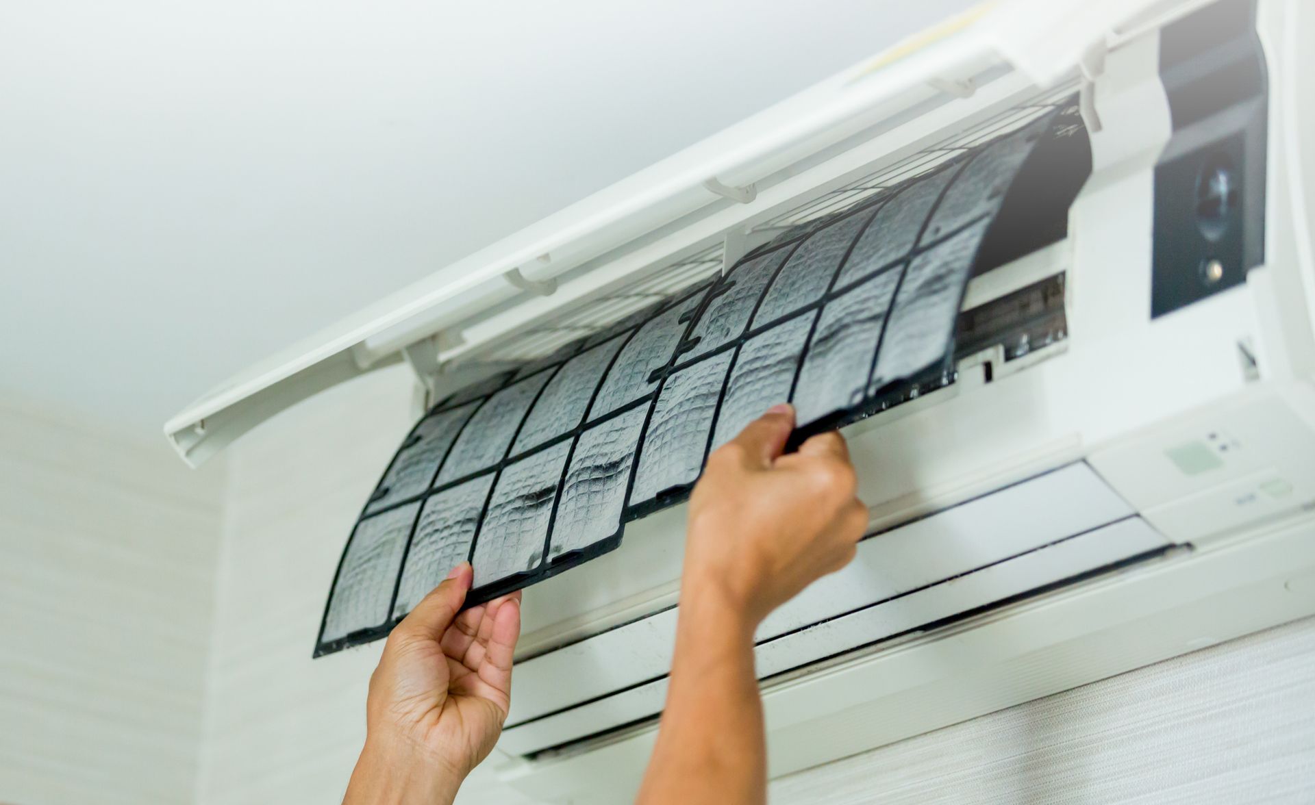A person is cleaning the filter of an air conditioner - Concord, NC - Concord Heating & Air conditioning